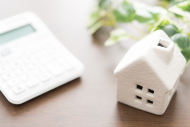 電卓と家の模型が置かれたテーブル